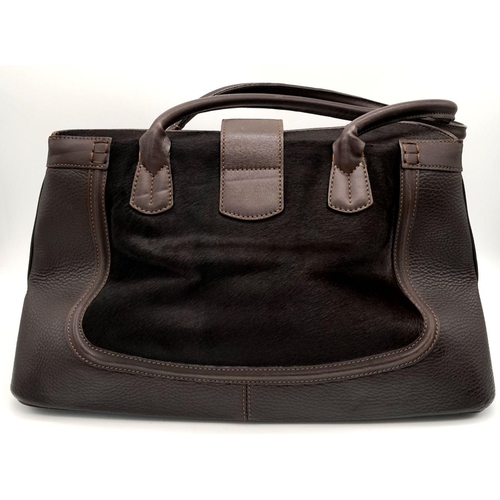 387 - A Tod's Brown Shoulder Bag. Leather and cavallino hair exterior with silver-toned hardware, two roll... 