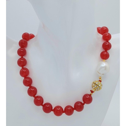 797 - A Fiery Red Jade Bead Necklace with a Baroque Pearl Interrupter. 12mm beads. 44cm necklace length. G... 