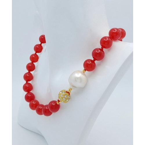 797 - A Fiery Red Jade Bead Necklace with a Baroque Pearl Interrupter. 12mm beads. 44cm necklace length. G... 