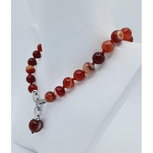 831 - A Luscious Red Striped Agate Beaded Necklace with Drop Pendant - 5cm. Beads - 10mm. Necklace length ... 