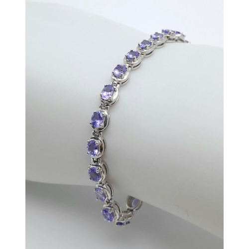 846 - A STERLING SILVER PURPLE/BLUE STONE SET BRACELET. 10.2G