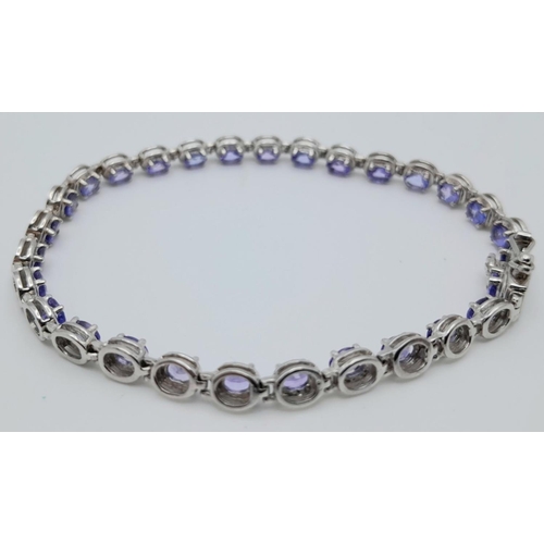 846 - A STERLING SILVER PURPLE/BLUE STONE SET BRACELET. 10.2G