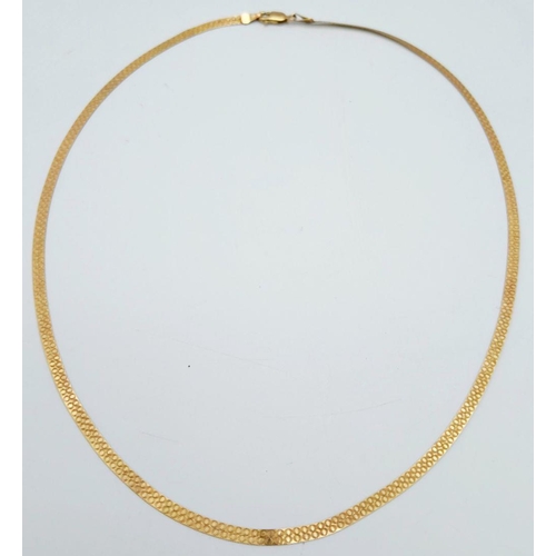 205 - A FLAT ELEGANT 9K GOLD NECKLACE WITH PATTERN ON ONE SIDE .  3.2gms