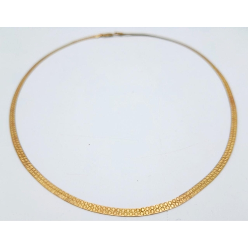 205 - A FLAT ELEGANT 9K GOLD NECKLACE WITH PATTERN ON ONE SIDE .  3.2gms