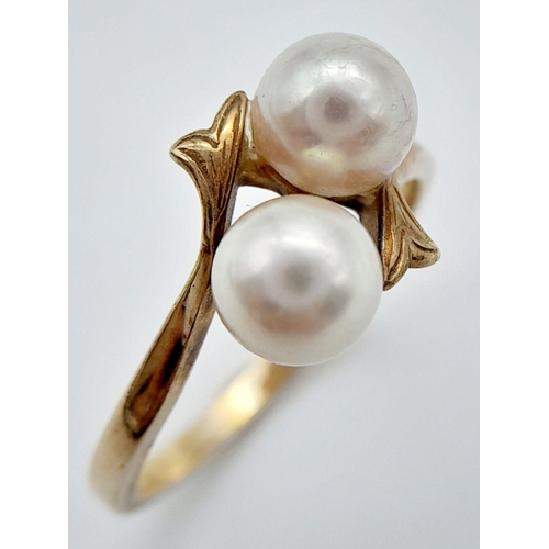 212 - A 9K GOLD CROSSOVER STYLE RING WITH TWIN PEARL TOP .     2.3gms   size N