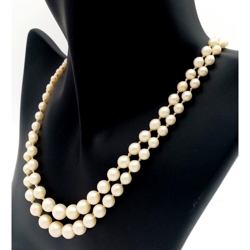 465 - A DOUBLE STRING OF GRADUATED PEARLS WITH A 9K GOLD CLASP.   28.9gms