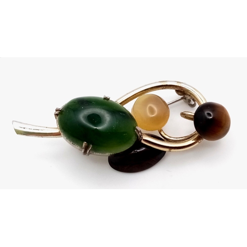 1441 - A Magical, Music Note Styled Multi-Gemstone Brooch. Jade, tigers eye, moonstone and agate hit the ri... 