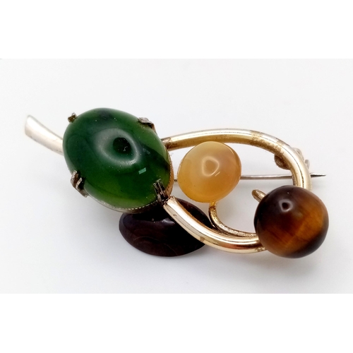 1441 - A Magical, Music Note Styled Multi-Gemstone Brooch. Jade, tigers eye, moonstone and agate hit the ri... 