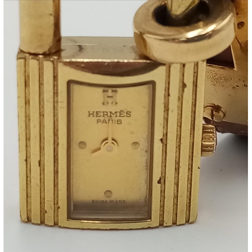 745 - A Hermes Kelly Watch. Brown leather strap. Gold plated padlock quartz watch. Needs a battery so as f... 