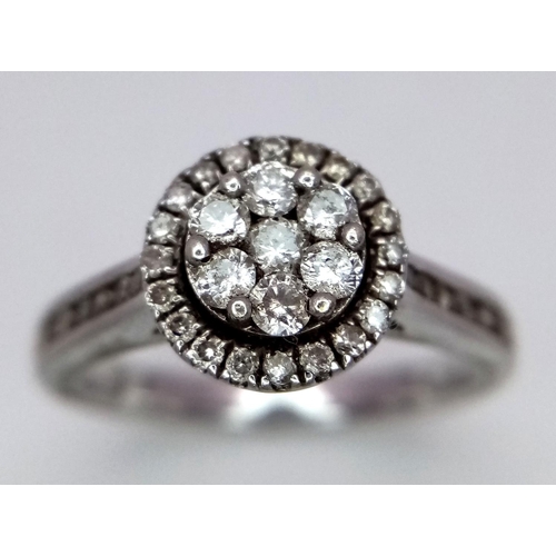 747 - A 9K White Gold Diamond Cluster Ring. Decorative floral shape. Size N. 4g total weight.