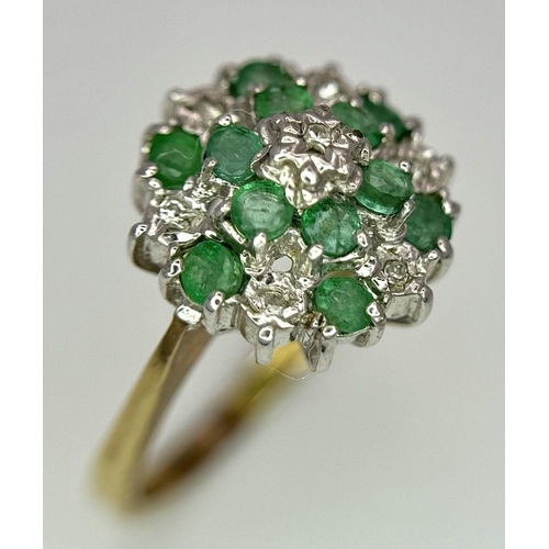 299 - A 9K YELLOW GOLD DIAMOND AND EMERALD CLUSTER RING. 2.7G. SIZE J.