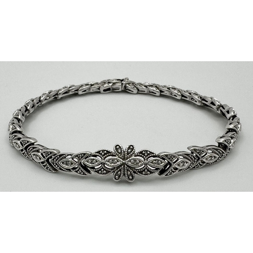 579 - A STERLING SILVER DIAMOND SET BRACELET -10.9G.