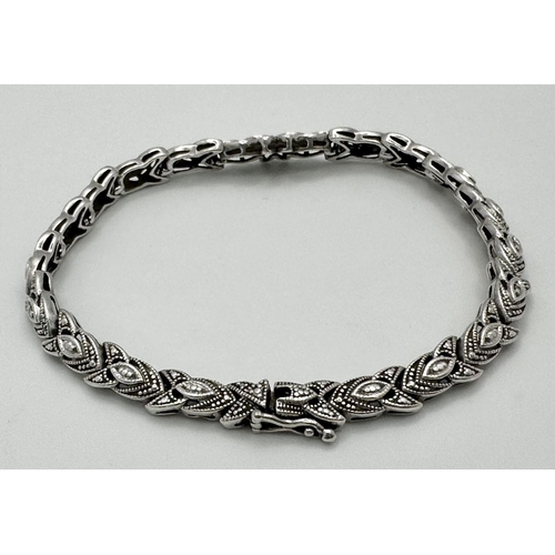 579 - A STERLING SILVER DIAMOND SET BRACELET -10.9G.