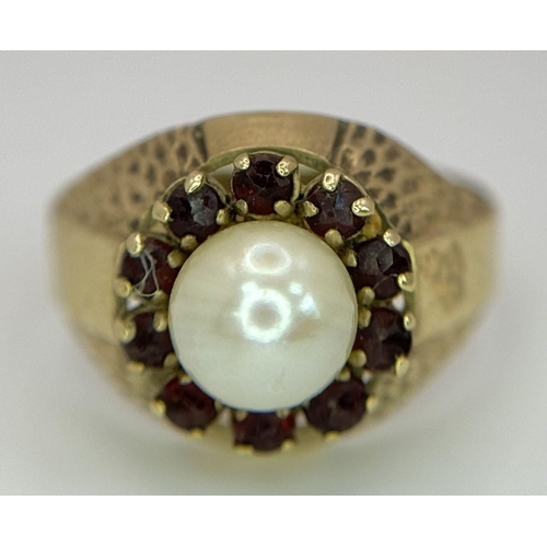 87 - AN UNUSUAL 8K GOLD RING WITH CENTRAL PEARL SURROUNDED BY GARNETS .. 3,2gms   size O