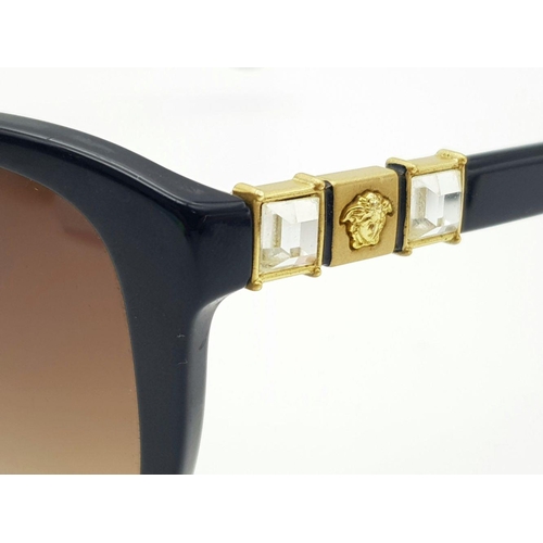 309 - A Pair of Designer Versace Black Sunglasses. White stone and logo embellishment to side frames. Come... 