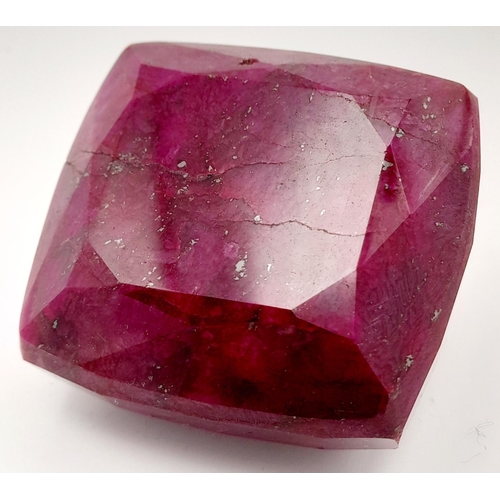 125 - A massive (676.8 carats) natural ruby, cushion cut, with evident secondary mineralisation as indicat... 