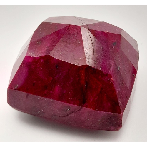 125 - A massive (676.8 carats) natural ruby, cushion cut, with evident secondary mineralisation as indicat... 