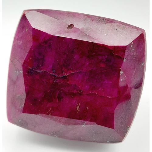 125 - A massive (676.8 carats) natural ruby, cushion cut, with evident secondary mineralisation as indicat... 