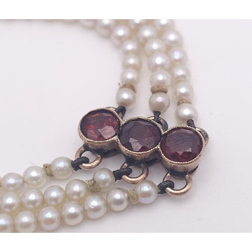 207 - An Antique 9K Gold (tested), Garnet and Pearl Bracelet. Different cuts of rich garnet gemstones amon... 