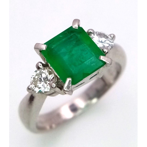 149 - A 900 Platinum Emerald and Diamond Ring. Central emerald with a 0.20 brilliant round cut diamond eit... 