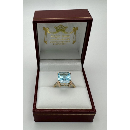 387 - A 9K Yellow Gold Blue Topaz and Diamond Ring. Central topaz with diamond accents. Size O. 3.9g total... 