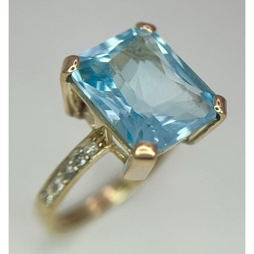 387 - A 9K Yellow Gold Blue Topaz and Diamond Ring. Central topaz with diamond accents. Size O. 3.9g total... 