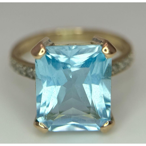 387 - A 9K Yellow Gold Blue Topaz and Diamond Ring. Central topaz with diamond accents. Size O. 3.9g total... 