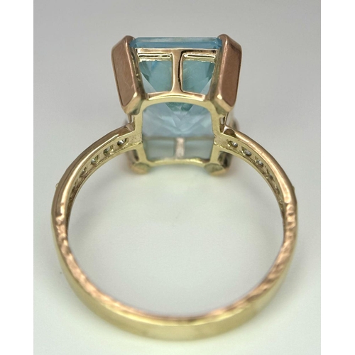 387 - A 9K Yellow Gold Blue Topaz and Diamond Ring. Central topaz with diamond accents. Size O. 3.9g total... 