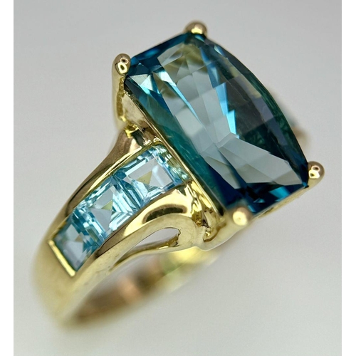 569 - A 9K Yellow Gold and London Blue Topaz Ring. Size M 1/2. 4.75g total weight. Comes with a presentati... 