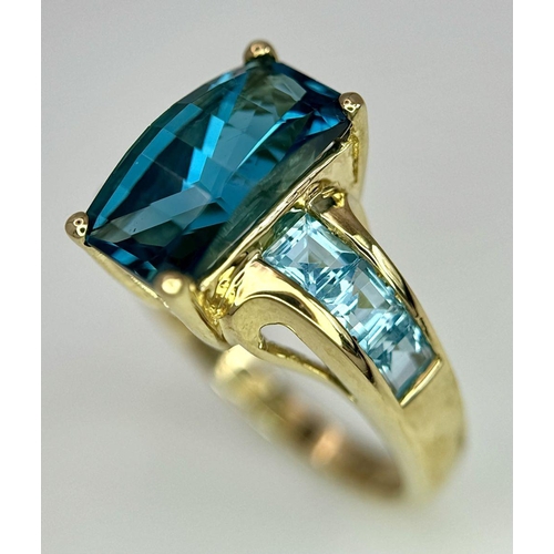 569 - A 9K Yellow Gold and London Blue Topaz Ring. Size M 1/2. 4.75g total weight. Comes with a presentati... 