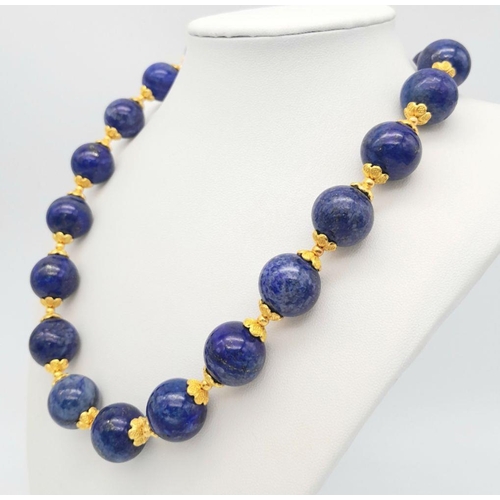 584 - A Large (20mm) Lapis Lazuli Beaded Necklace with Gilded Coronet Spacers and Clasp. 48cm necklace len... 