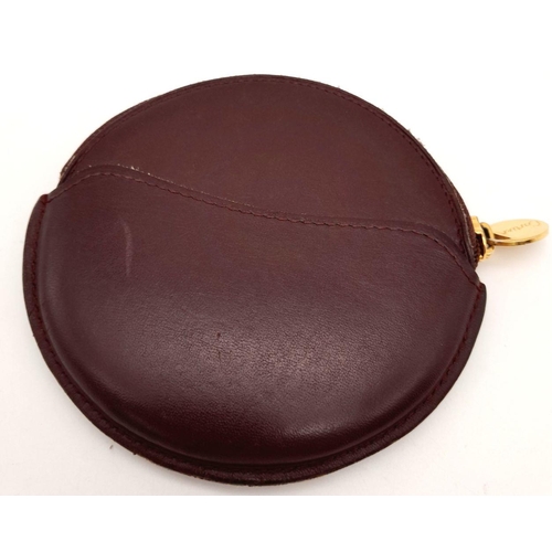 611 - A Burgundy Cartier Purse. Leather exterior, zipper closure, gold-tone hardware and a open side pocke... 