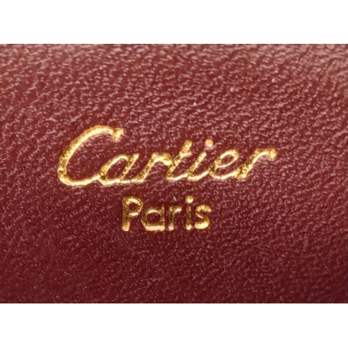 611 - A Burgundy Cartier Purse. Leather exterior, zipper closure, gold-tone hardware and a open side pocke... 