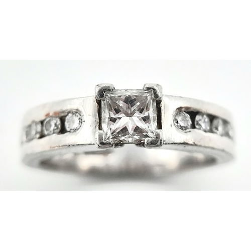 100 - A 950 Platinum Diamond Ring. A 0.30ct princess cut central diamond with five round cut diamonds on e... 