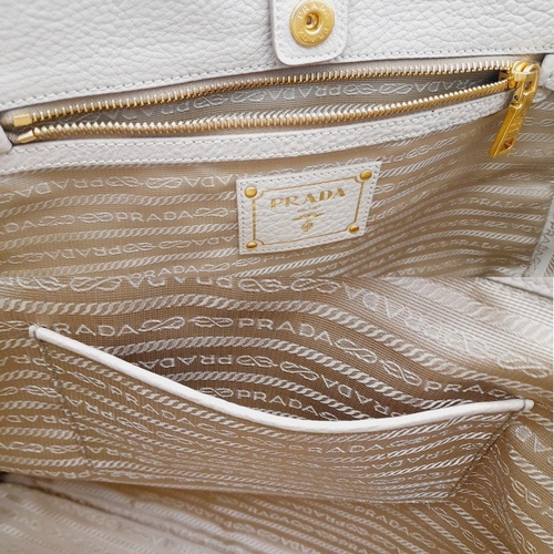 338 - A Prada Cream Leather Tote Bag. Dual flat handles, gold tone hardware. Exterior pocket to each side.... 