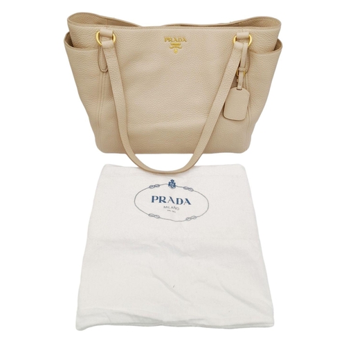 338 - A Prada Cream Leather Tote Bag. Dual flat handles, gold tone hardware. Exterior pocket to each side.... 