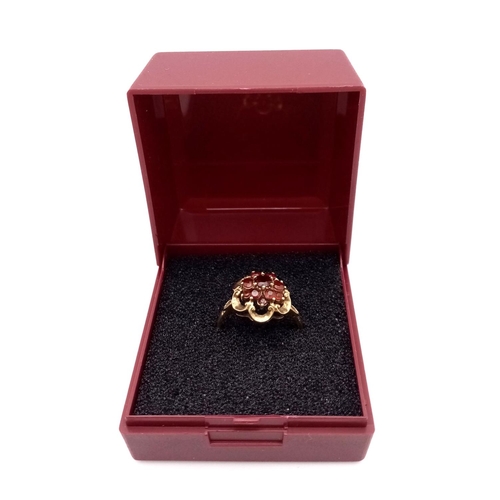 364 - Hallmarked 9 carat GOLD,GARNET CLUSTER RING. Complete with ring box.2.1 grams. Size K.