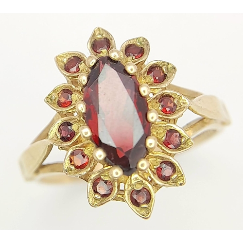 386 - A 9K GOLD RING WITH A REGAL DESIGN OF GARNET STONES .    3.1gms   size O