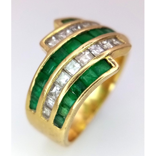 85 - An 18K Yellow Gold Emerald and Diamond Swirl Ring. 0.6ctw emeralds, 0.5ctw diamonds approx. Size K. ... 