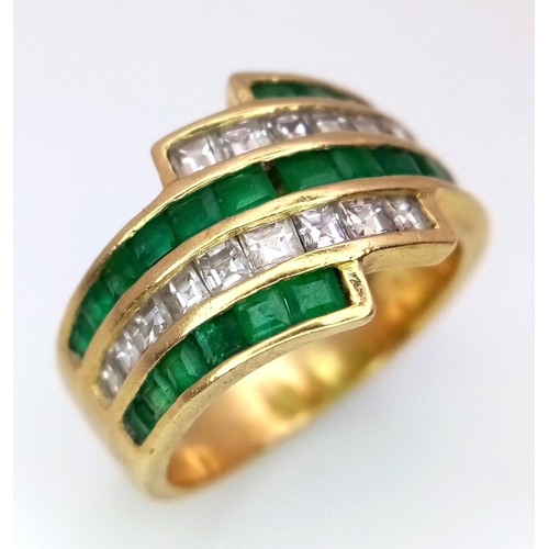 85 - An 18K Yellow Gold Emerald and Diamond Swirl Ring. 0.6ctw emeralds, 0.5ctw diamonds approx. Size K. ... 