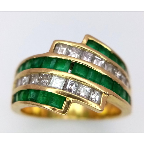 85 - An 18K Yellow Gold Emerald and Diamond Swirl Ring. 0.6ctw emeralds, 0.5ctw diamonds approx. Size K. ... 