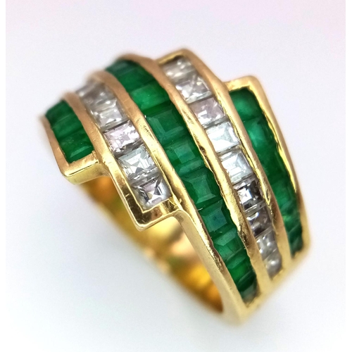 85 - An 18K Yellow Gold Emerald and Diamond Swirl Ring. 0.6ctw emeralds, 0.5ctw diamonds approx. Size K. ... 