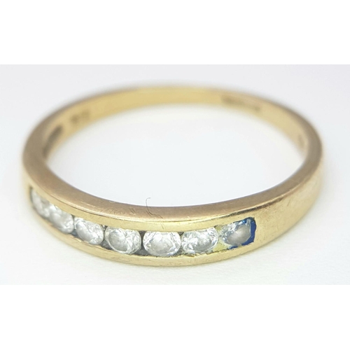 379 - A 9K GOLD RING WITH 7 CZ STONES CHANNEL SET IN IT.    1.6gms   size P