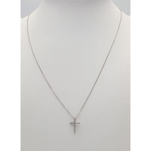 403 - A 14k white gold diamond cross necklace on 18