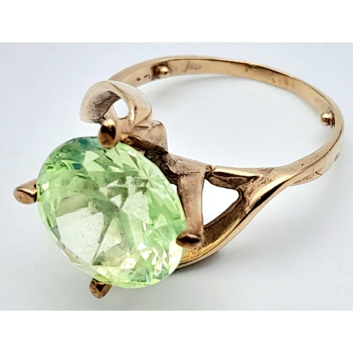 463 - A 9K GOLD DRESS RING WITH A LARGE FACETED GREEN STONE IN CLAW SETTING .   4.4gms   size L