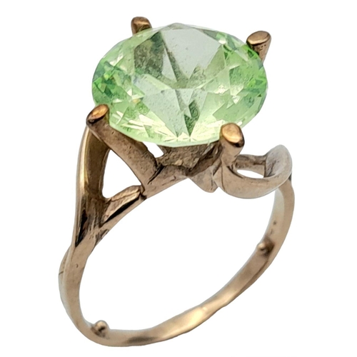 463 - A 9K GOLD DRESS RING WITH A LARGE FACETED GREEN STONE IN CLAW SETTING .   4.4gms   size L