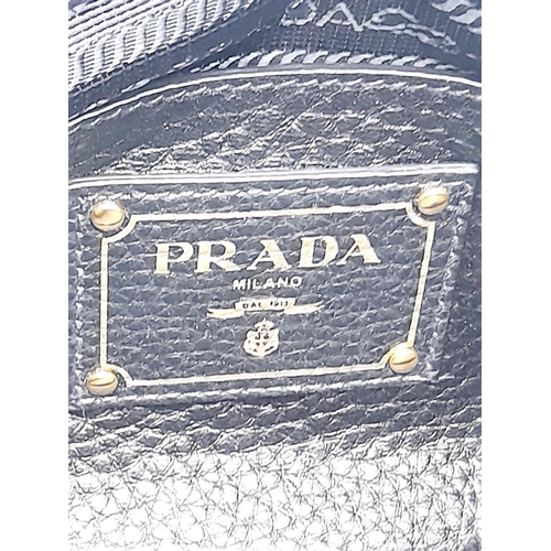 127 - A Prada Black Vitello Daino Tote Bag. Grained black leather exterior, gold-tone hardware, two rounde... 