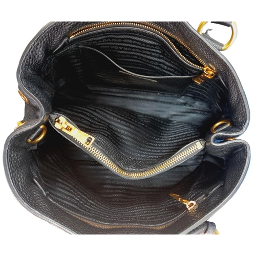 127 - A Prada Black Vitello Daino Tote Bag. Grained black leather exterior, gold-tone hardware, two rounde... 