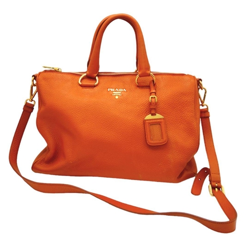 113 - A Prada Orange Vitello Daino Satchel Bag. Leather exterior, gold-tone hardware, double rolled leathe... 