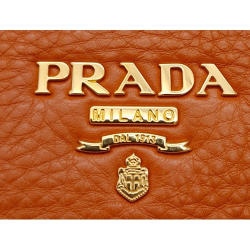 113 - A Prada Orange Vitello Daino Satchel Bag. Leather exterior, gold-tone hardware, double rolled leathe... 